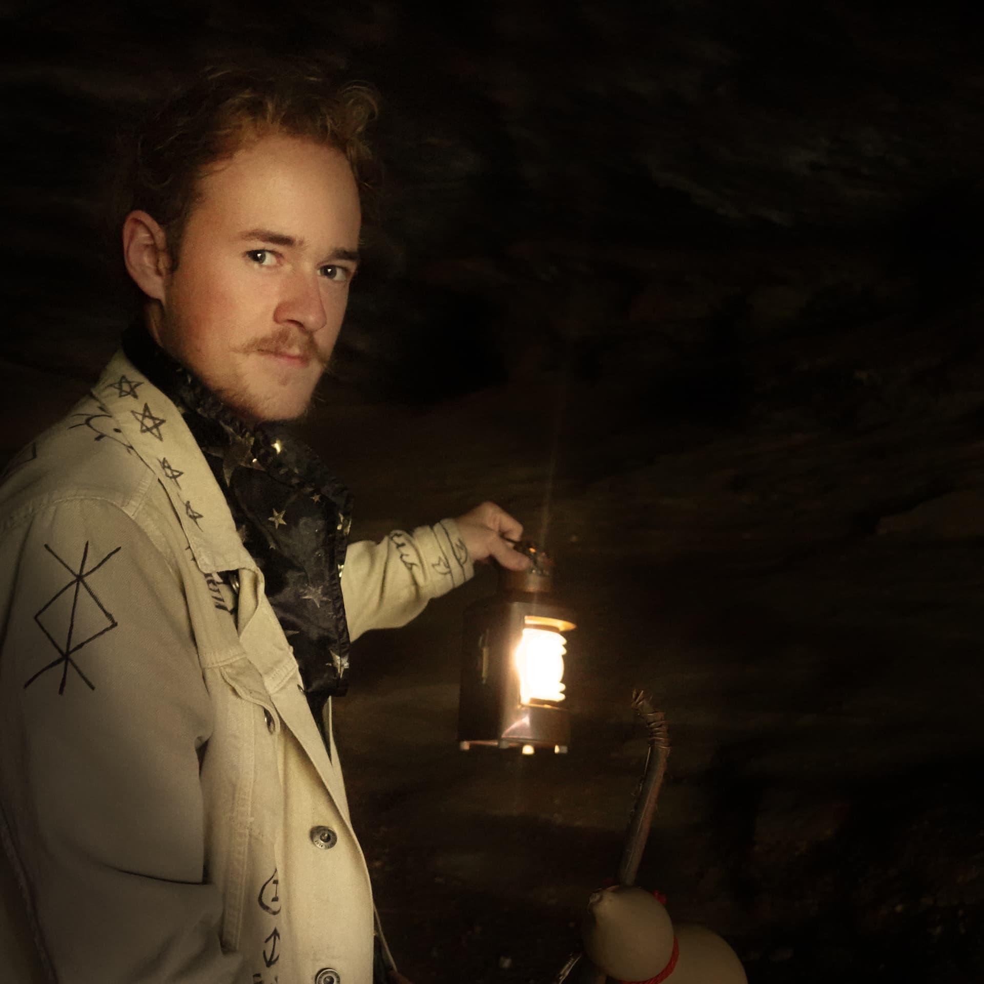 Filip Strüven mit einer Laterne in einer Höhle